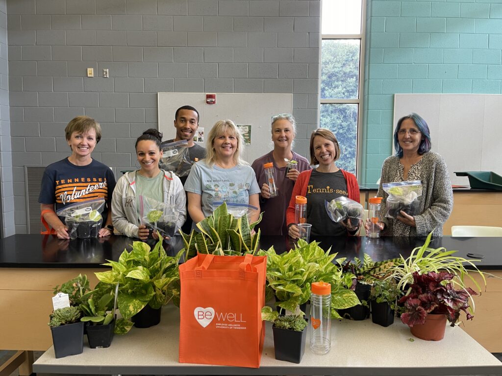 A group of people smiling with plants