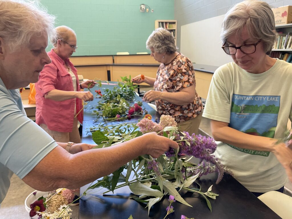 Women gathered around a table looking at plants