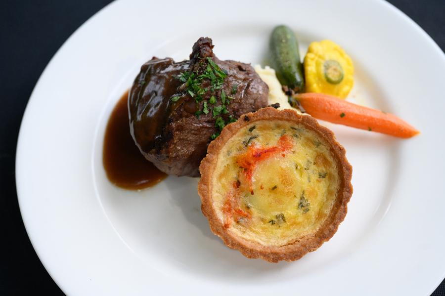 7-ounce UT Beef chargrilled filet with a bordelaise sauce and lobster tart accompanied by truffle oil mashed potatoes and fresh baby vegetables